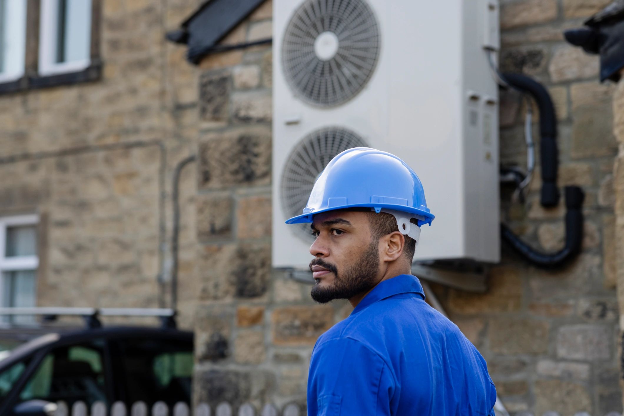 Heating service technician standing outside a home